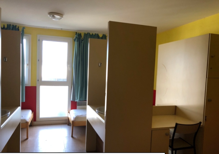Chambre de 4 lits avec bureaux, lavabo et grandes armoires